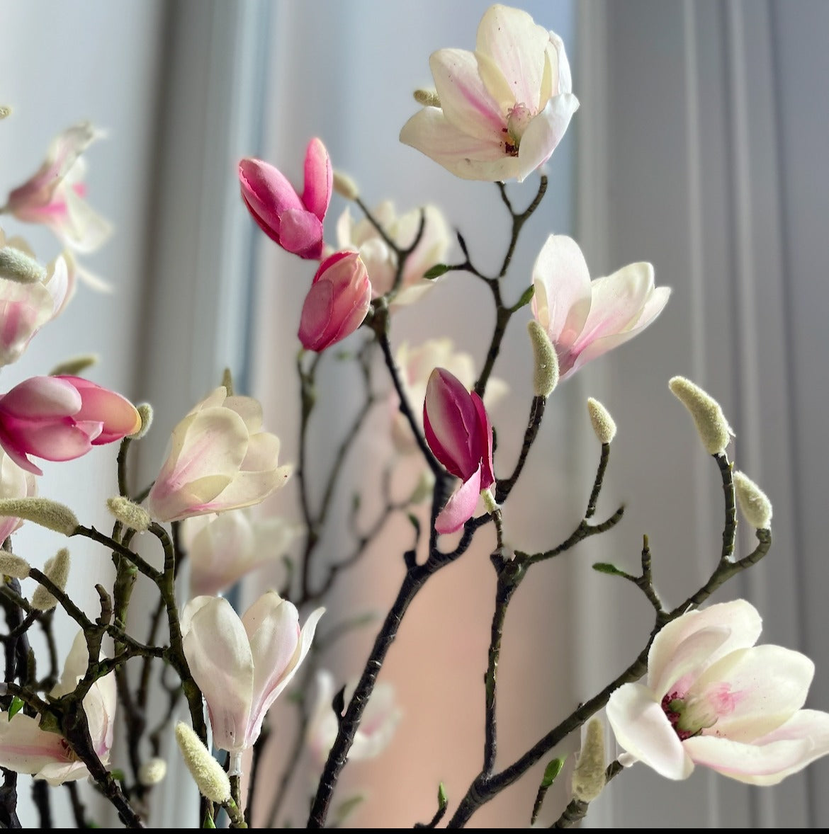 Large faux magnolia branch with pink blush and white flowers and real touch green leaves.