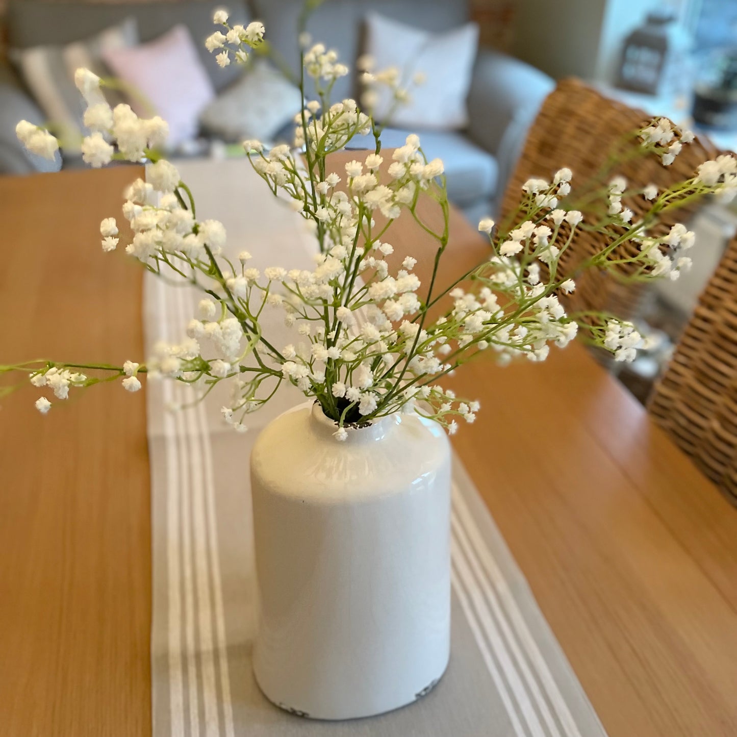 Faux white gypsophila stems arranged in a vase, styled with five stems