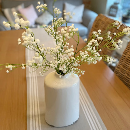 Faux white gypsophila stems arranged in a vase, styled with five stems