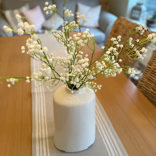 Faux white gypsophila stems arranged in a vase, styled with five stems
