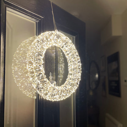 Galaxy wreath with 960 warm white LED lights on silver metal frame. Styled on a front door.