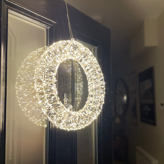 Galaxy wreath with 960 warm white LED lights on silver metal frame. Styled on a front door.