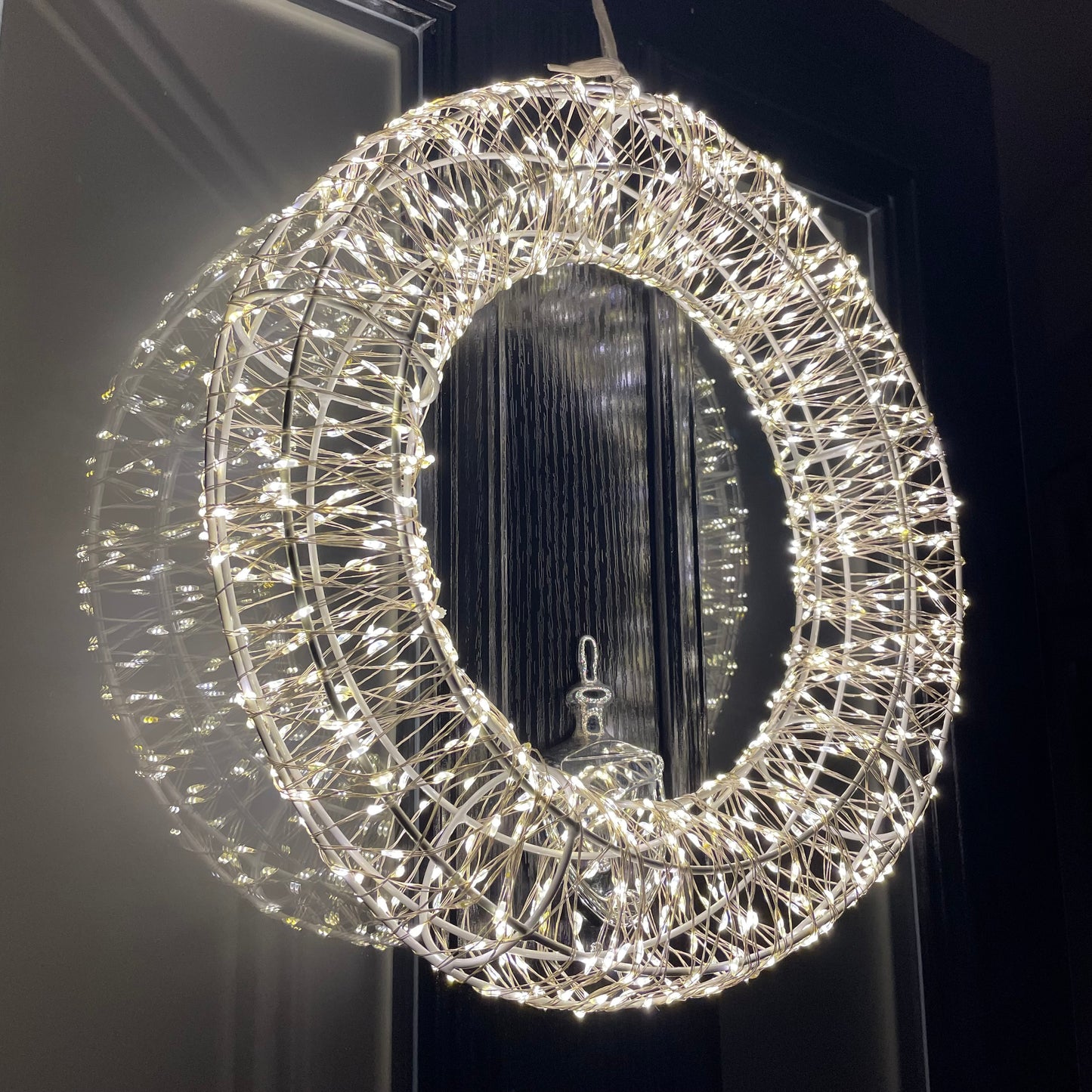Close up of shimmering LED Galaxy wreath twinkling on a front door.