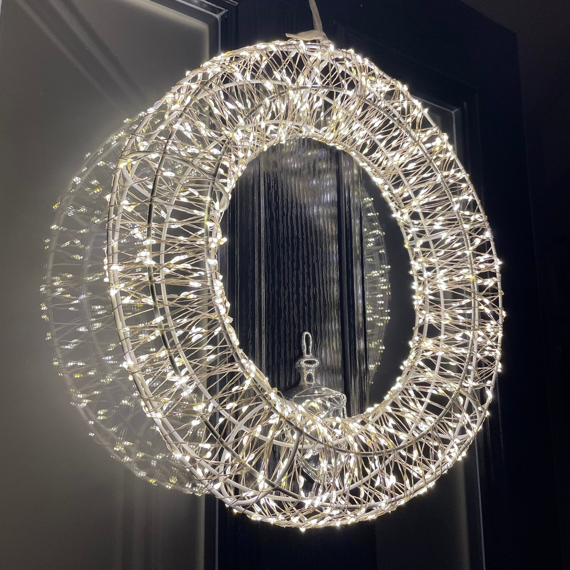 Close up of shimmering LED Galaxy wreath twinkling on a front door.