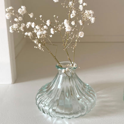 Small round glass bud vases with candles and flowers, perfect for a simple table setting.
