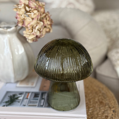 Decorative glass mushroom on a surface with a blurred background