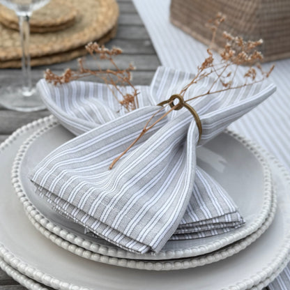 Natural cotton napkins in classic grey stripes, bringing simple, washable elegance to a calm and inviting tablescape.