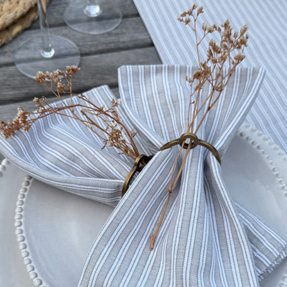 Natural cotton napkins in classic grey stripes, bringing simple, washable elegance to a calm and inviting tablescape.