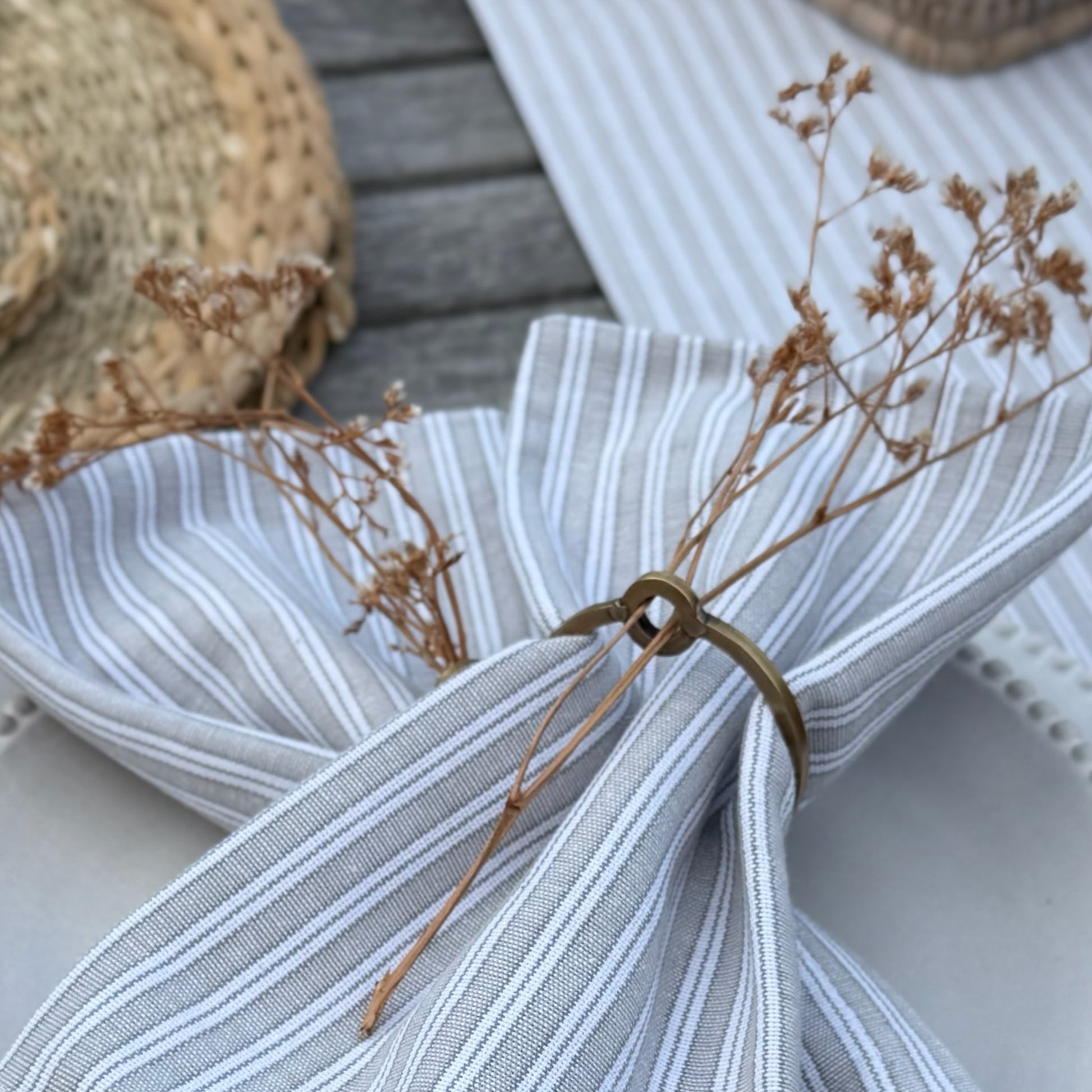 Natural cotton napkins in classic grey stripes, bringing simple, washable elegance to a calm and inviting tablescape.