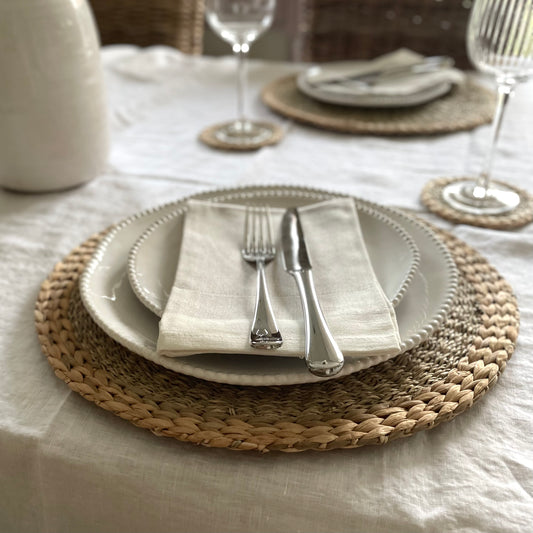 Natural woven seagrass and hyacinth placemats styled on dining table. 