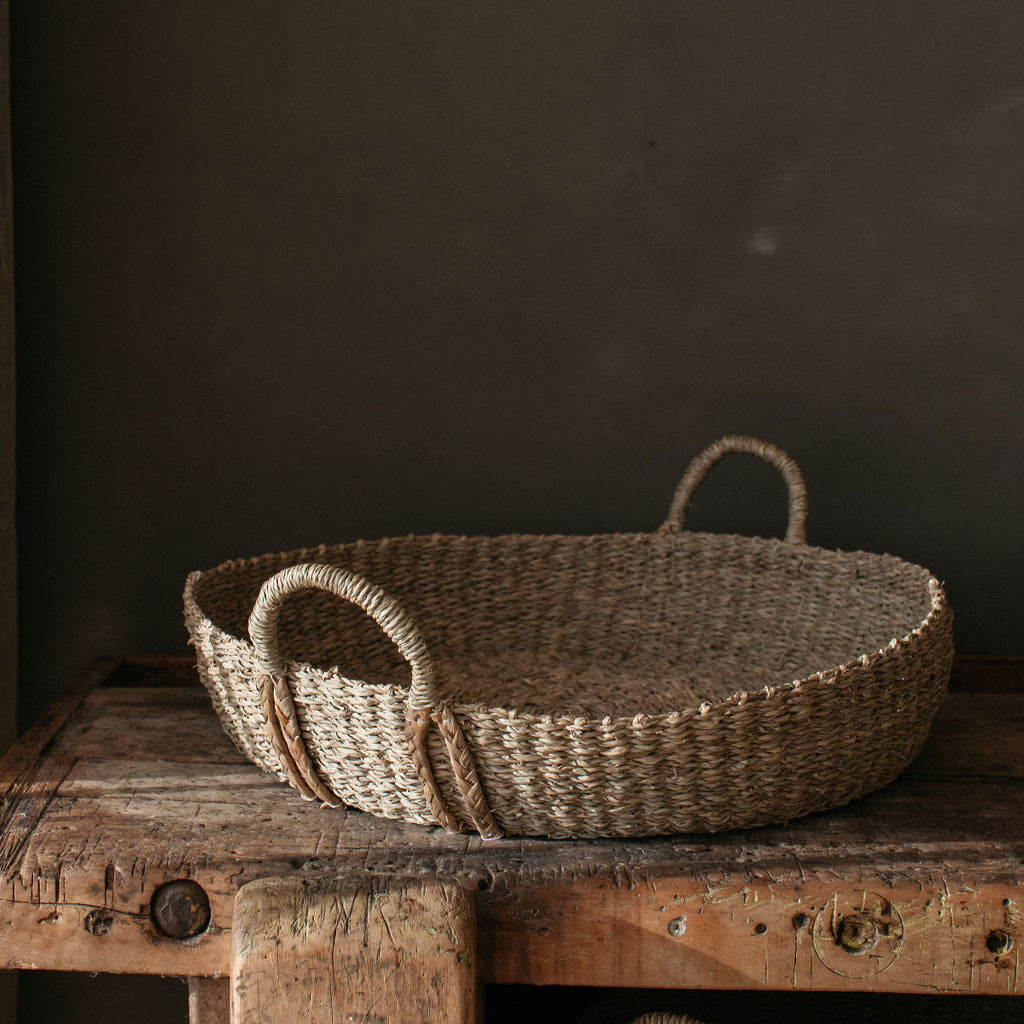 Shallow seagrass basket showcasing its natural weave and textured finish, perfect for styling with decor or seasonal accents.