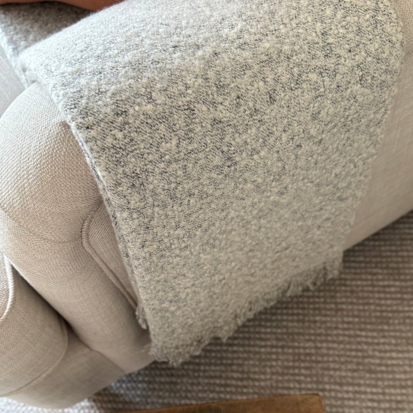 Soft, textural boucle throw styled on a sofa, perfect for creating a cosy, calm, and timeless atmosphere in your home.