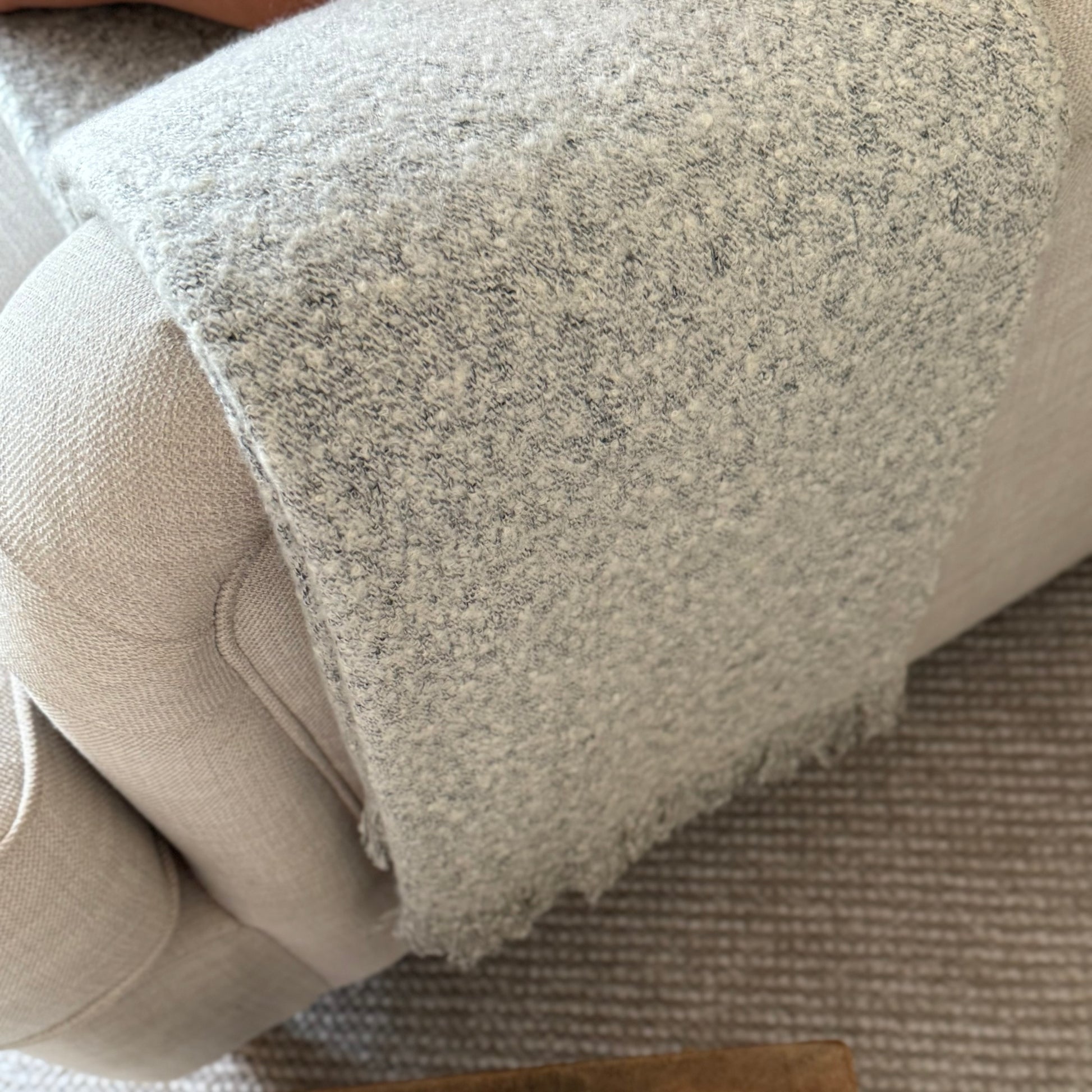 Soft, textural boucle throw styled on a sofa, perfect for creating a cosy, calm, and timeless atmosphere in your home.