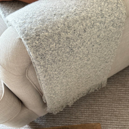 Soft, textural boucle throw styled on a sofa, perfect for creating a cosy, calm, and timeless atmosphere in your home.