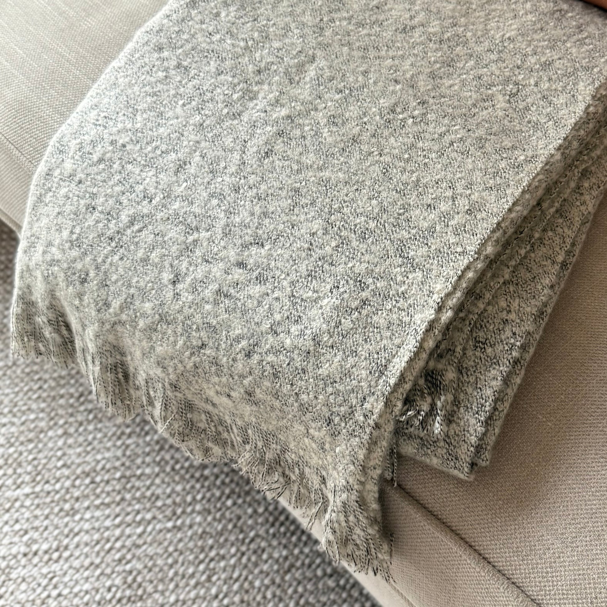 Soft, textural boucle throw styled on a sofa, perfect for creating a cosy, calm, and timeless atmosphere in your home