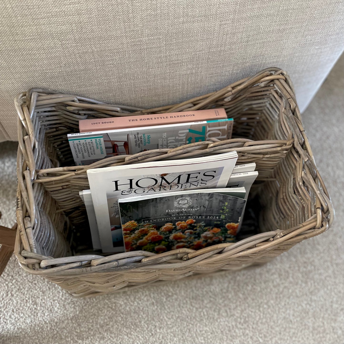 Natural rattan storage magazine holder with integral handle and full of magazines.
