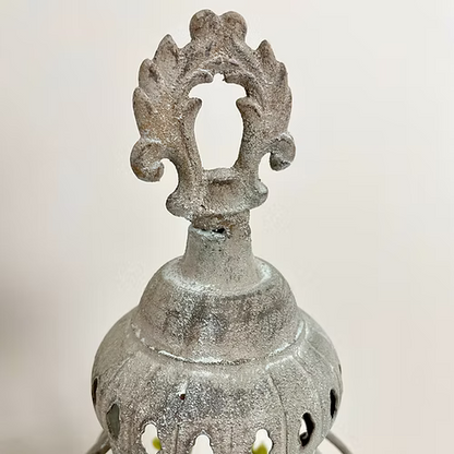 Decorative metal lantern with intricate design on a light background