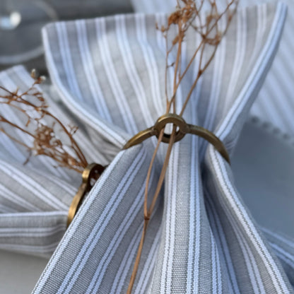 Set of classic napkin rings designed for lifetime use, shown with delicate floral sprigs to enhance a beautiful tablescape.