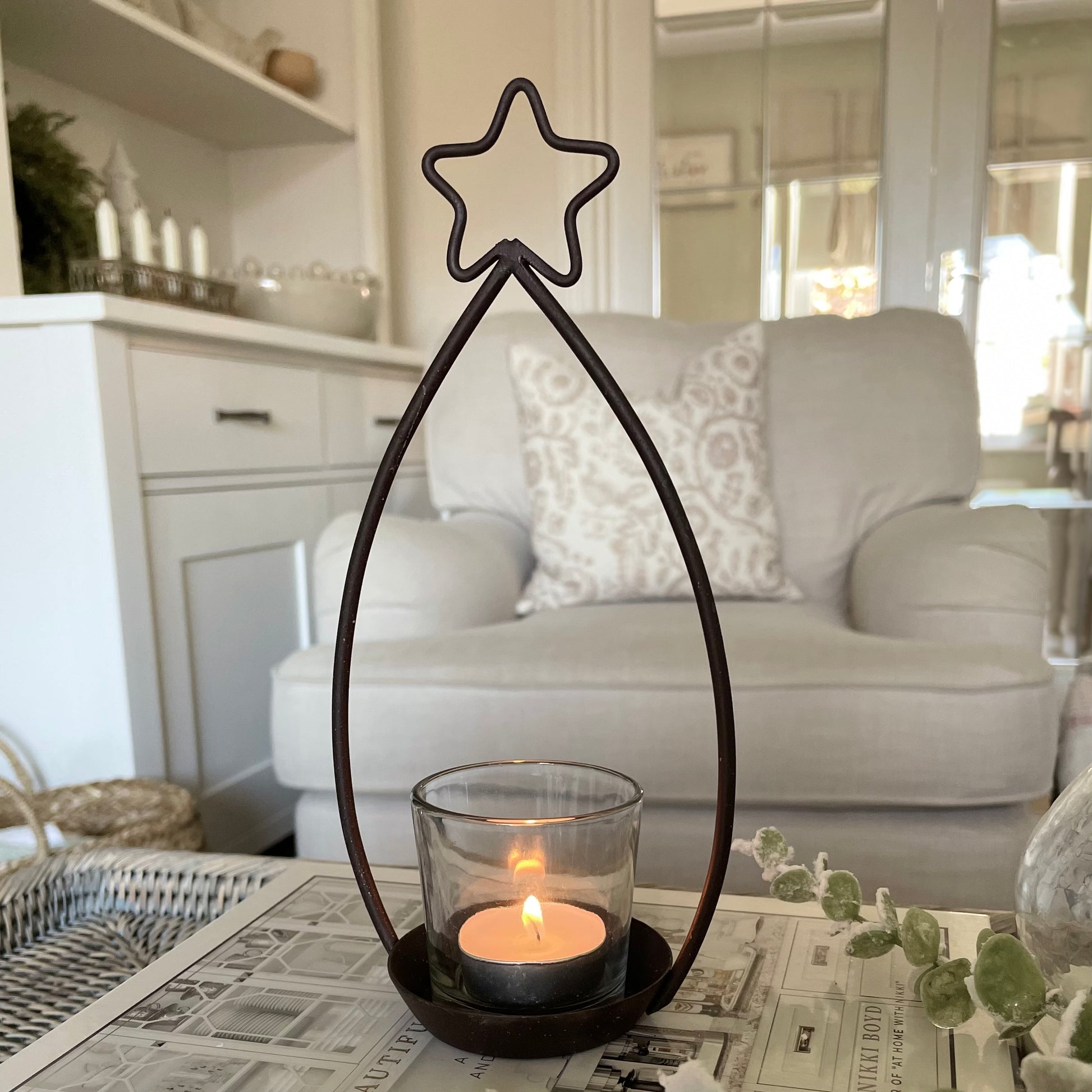 Metal star shaped tea light holder with glass votive.