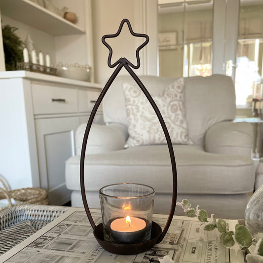 Metal star shaped tea light holder with glass votive.
