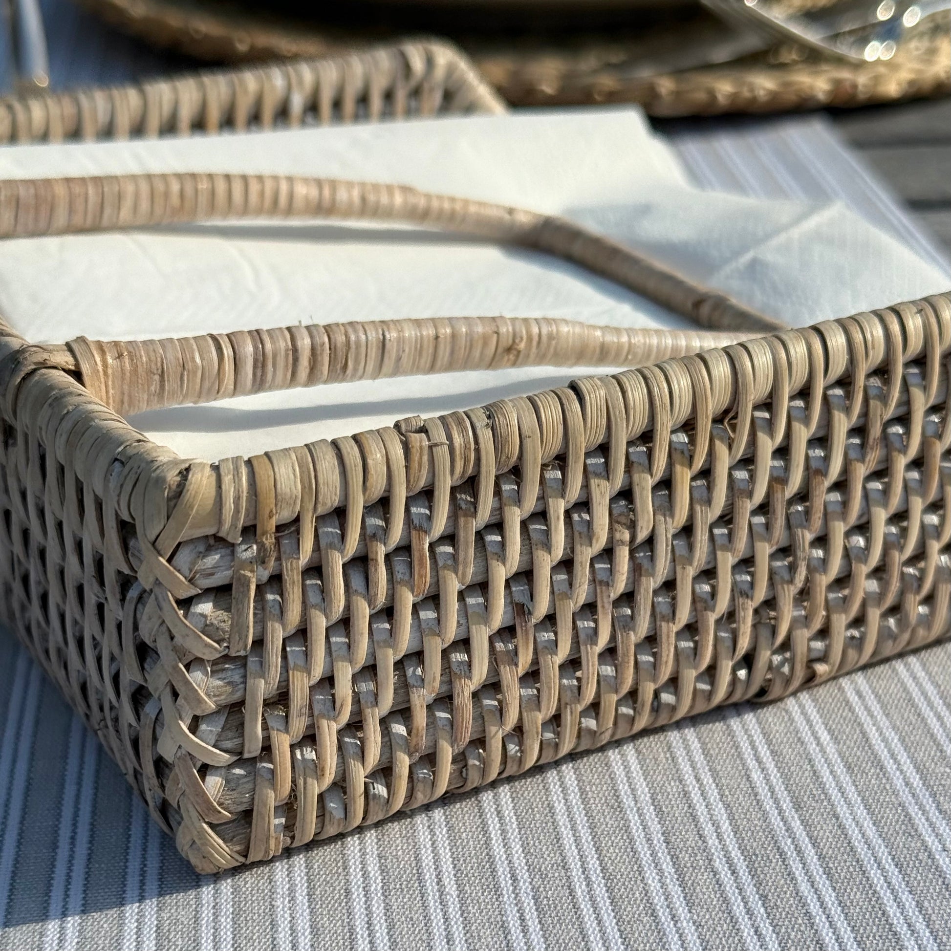 Handwoven rattan napkin holder with weighted arm, perfect for everyday dining and kitchen styling.