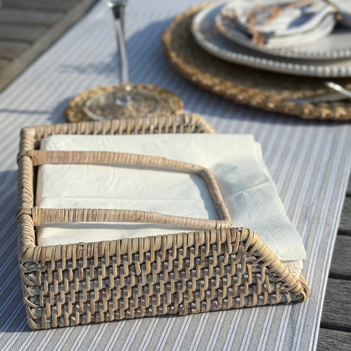 Handwoven rattan napkin holder with weighted arm, perfect for everyday dining and kitchen styling.