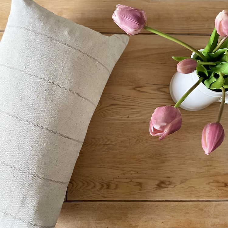 Soft linen blend cushion with subtle beige stripes, perfect for layering on sofas, chairs, or beds in a neutral interior.