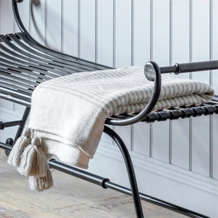 Soft neutral striped cream and beige throw with beige tassel corners, styled on a bench.