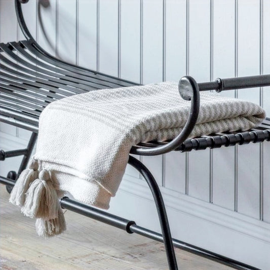Soft neutral striped cream and beige throw with beige tassel corners, styled on a bench.