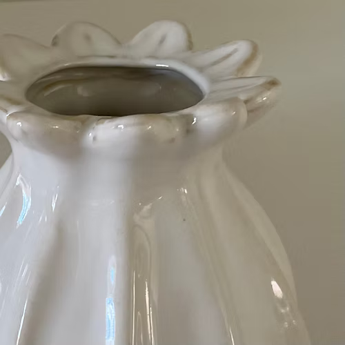 White ceramic poppy vase close up of neck edging.