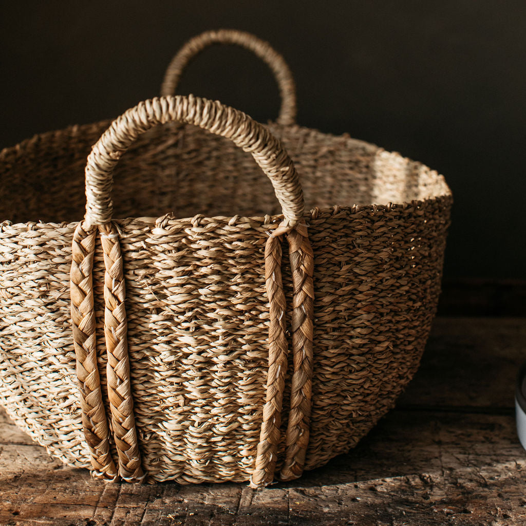 Handwoven deep oval basket made from natural seagrass, combining rustic texture with refined, practical design for any room.