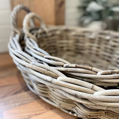 Natural tone rattan basket, perfect for carrying tableware or as a decorative centrepiece in any neutral interior.
