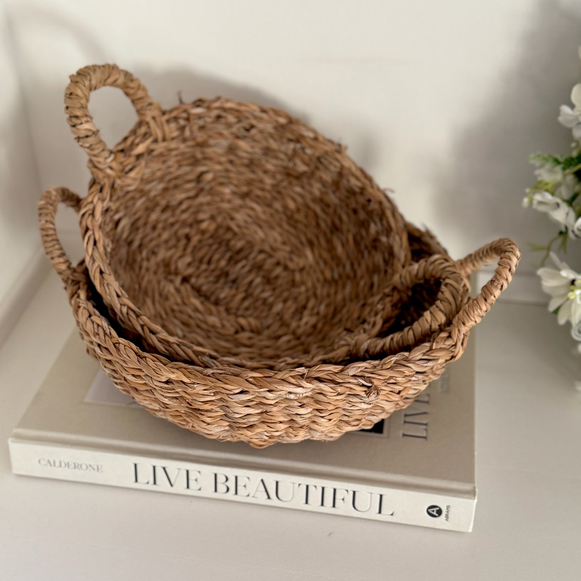 Two woven baskets on a book with a blurred background