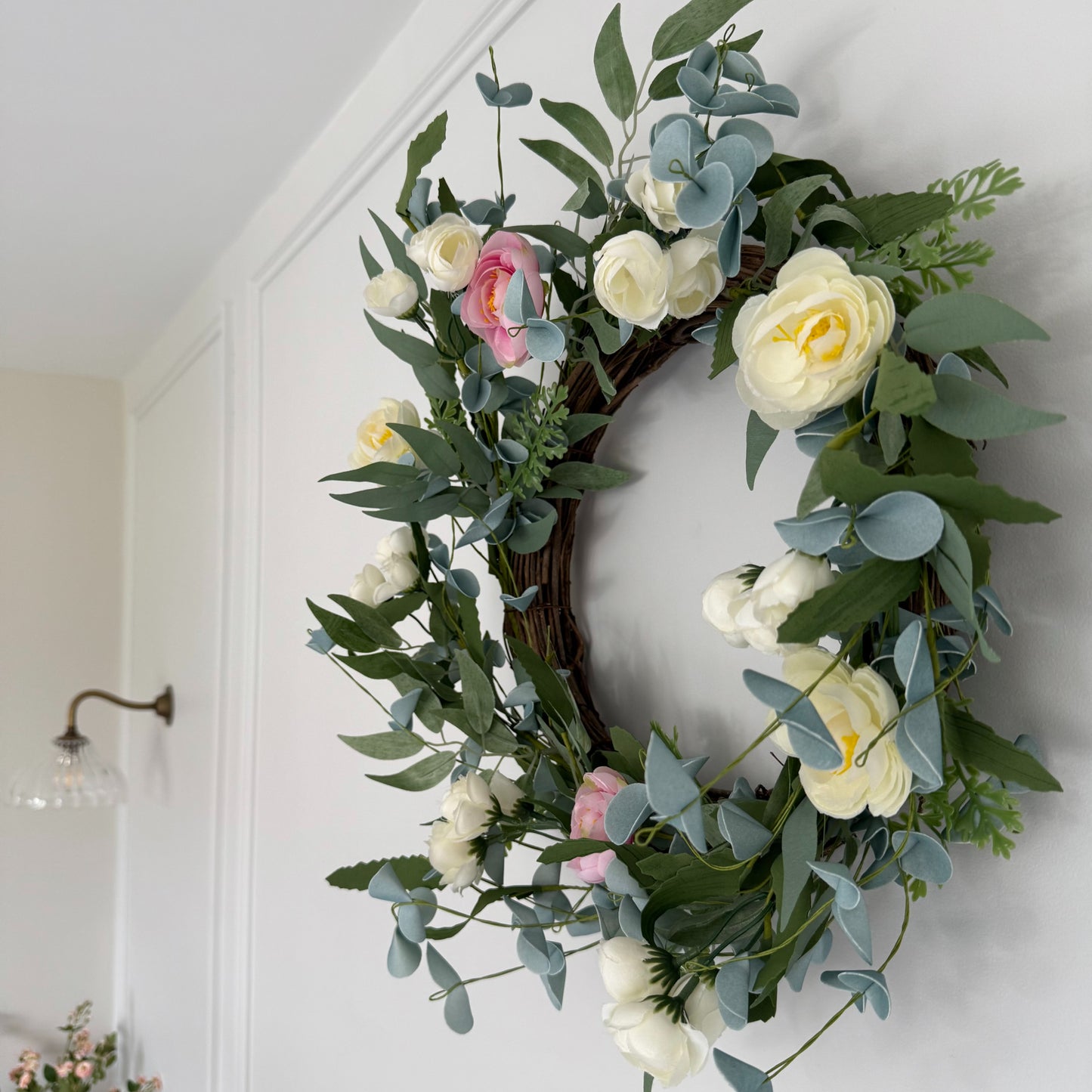 45cm faux spring wreath with pink and cream roses on a grapevine base. Styled on a white panelled wall.