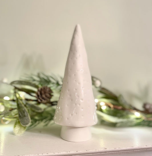 Porcelain Christmas tree styled on a console table with a festive garland.