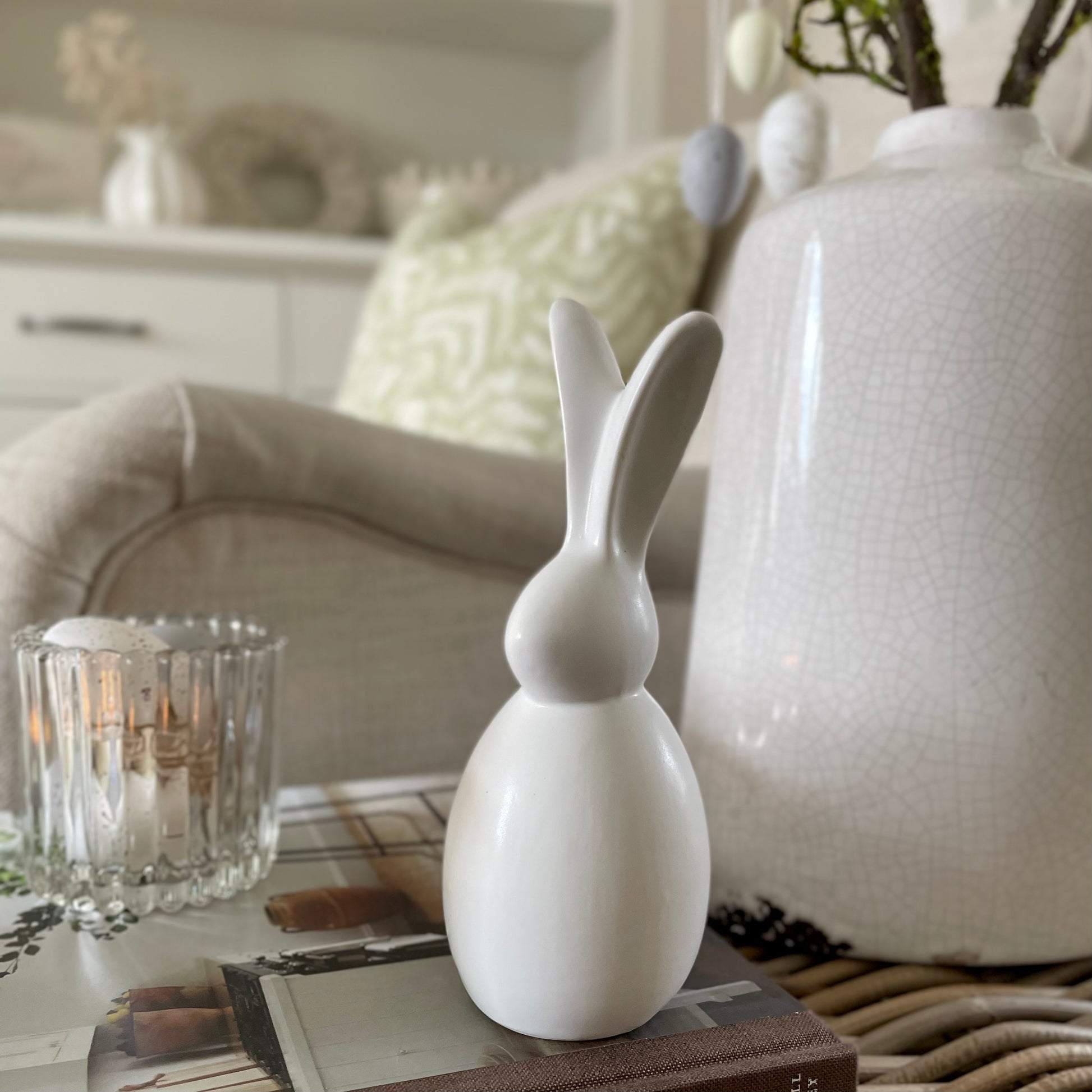 Minimalist porcelain bunny for seasonal home styling. With moss branches and decorative speckled eggs.