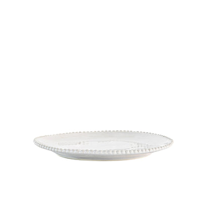 White porcelain side plate with organic shape and beaded detailing around the rim. Styled in front of white background.