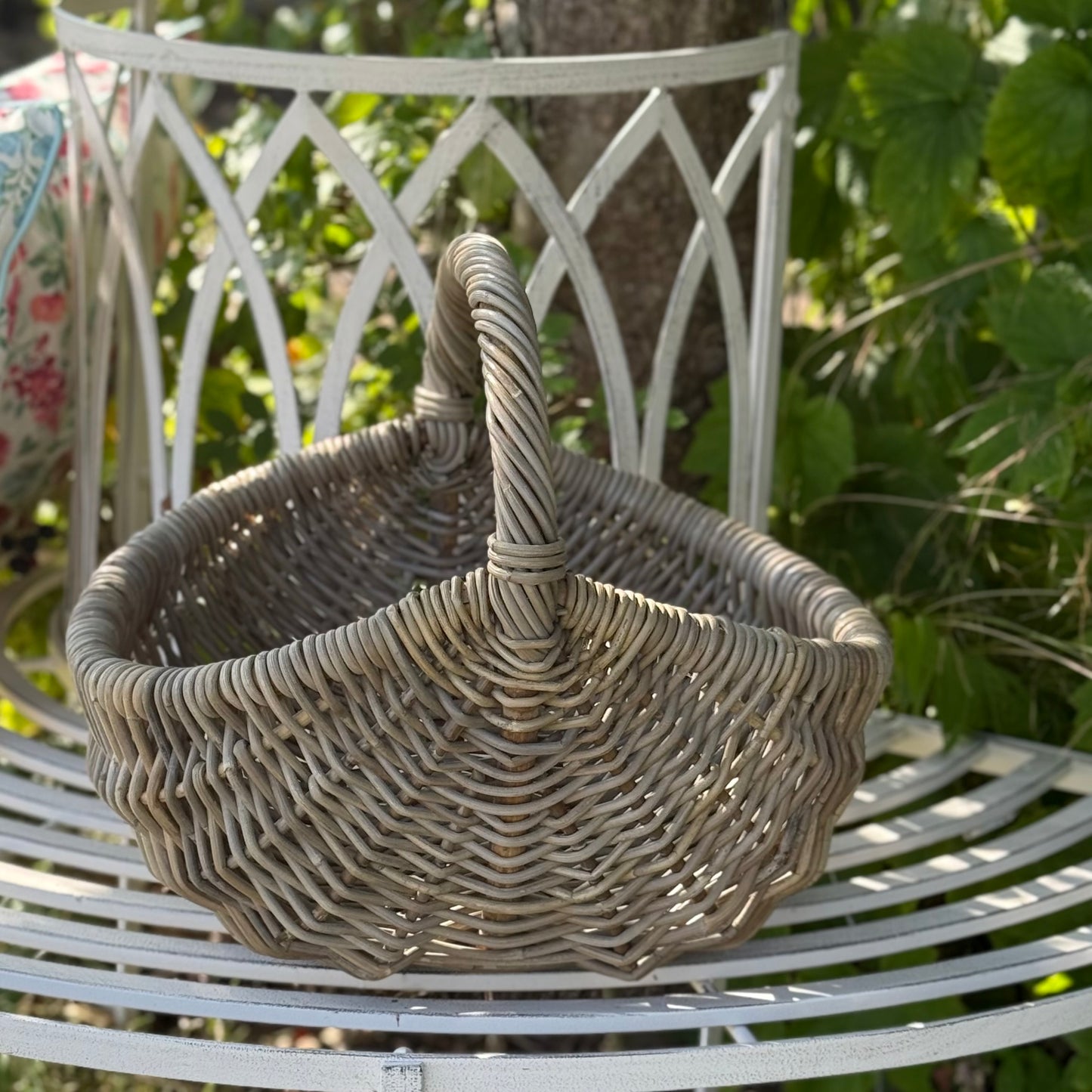 Handwoven rattan basket with circular handle, perfect for flowers, kindling or home storage. Perfect for country living.