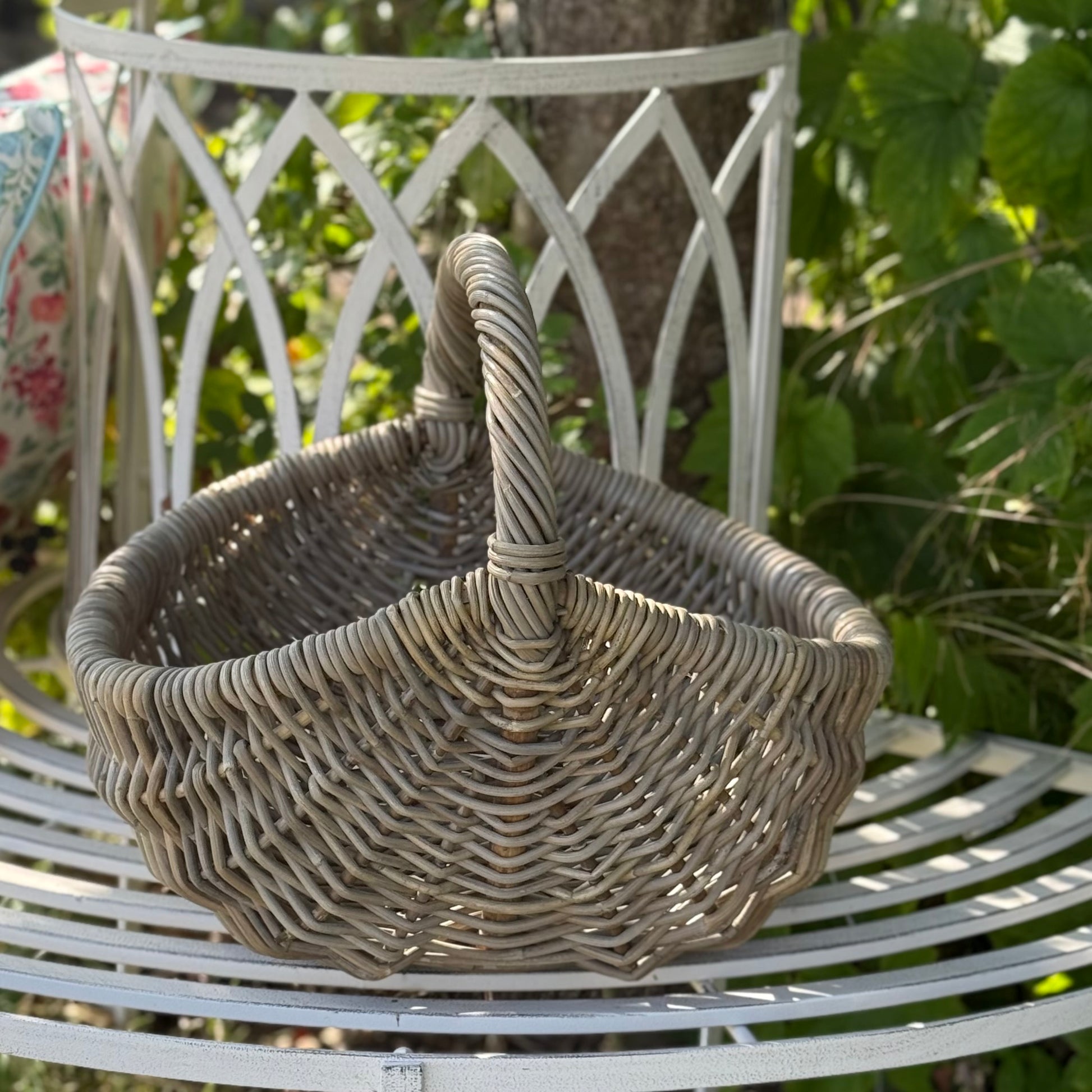 Handwoven rattan basket with circular handle, perfect for flowers, kindling or home storage. Perfect for country living.