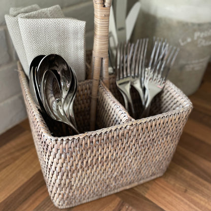 Close up of whitewashed rattan caddy texture. Shown with cutlery and napkins.