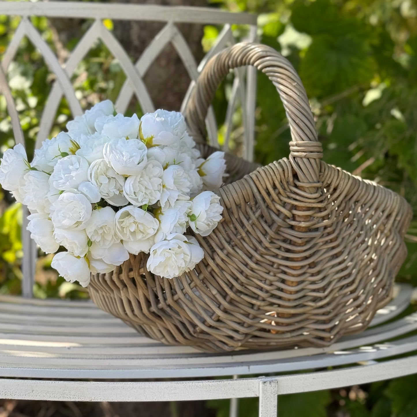 Handwoven rattan basket with circular handle, perfect for flowers, kindling or home storage.