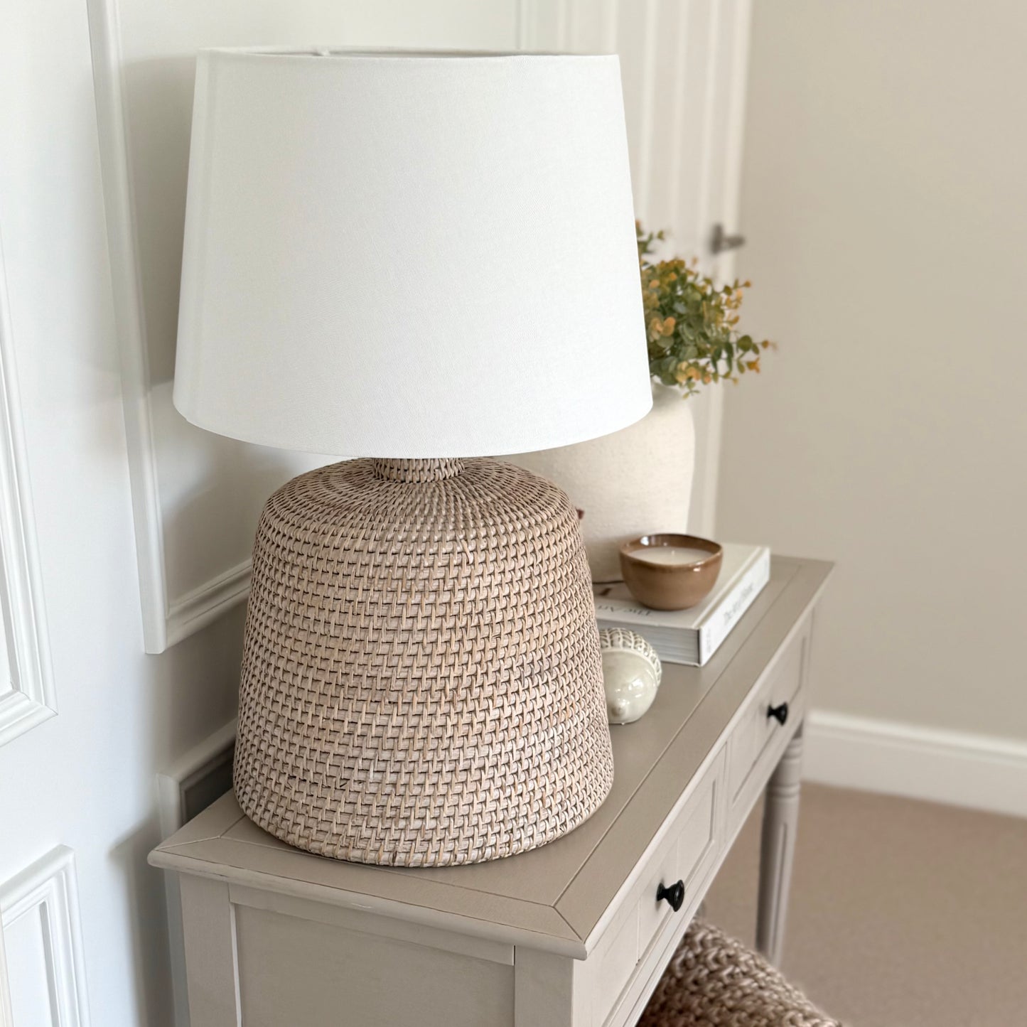 Handwoven rattan table lamp with whitewashed finish, available with or without shade.