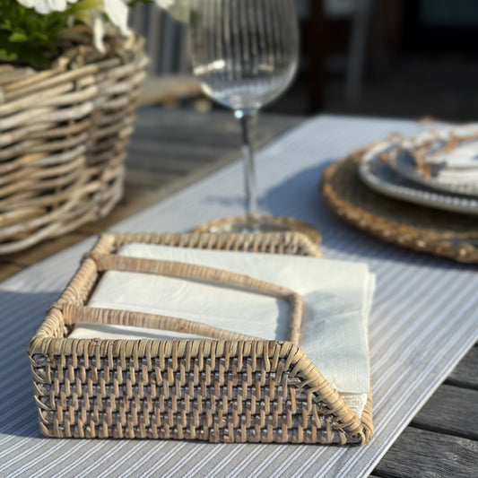 Rustic rattan napkin holder crafted from natural materials with practical weighted arm.