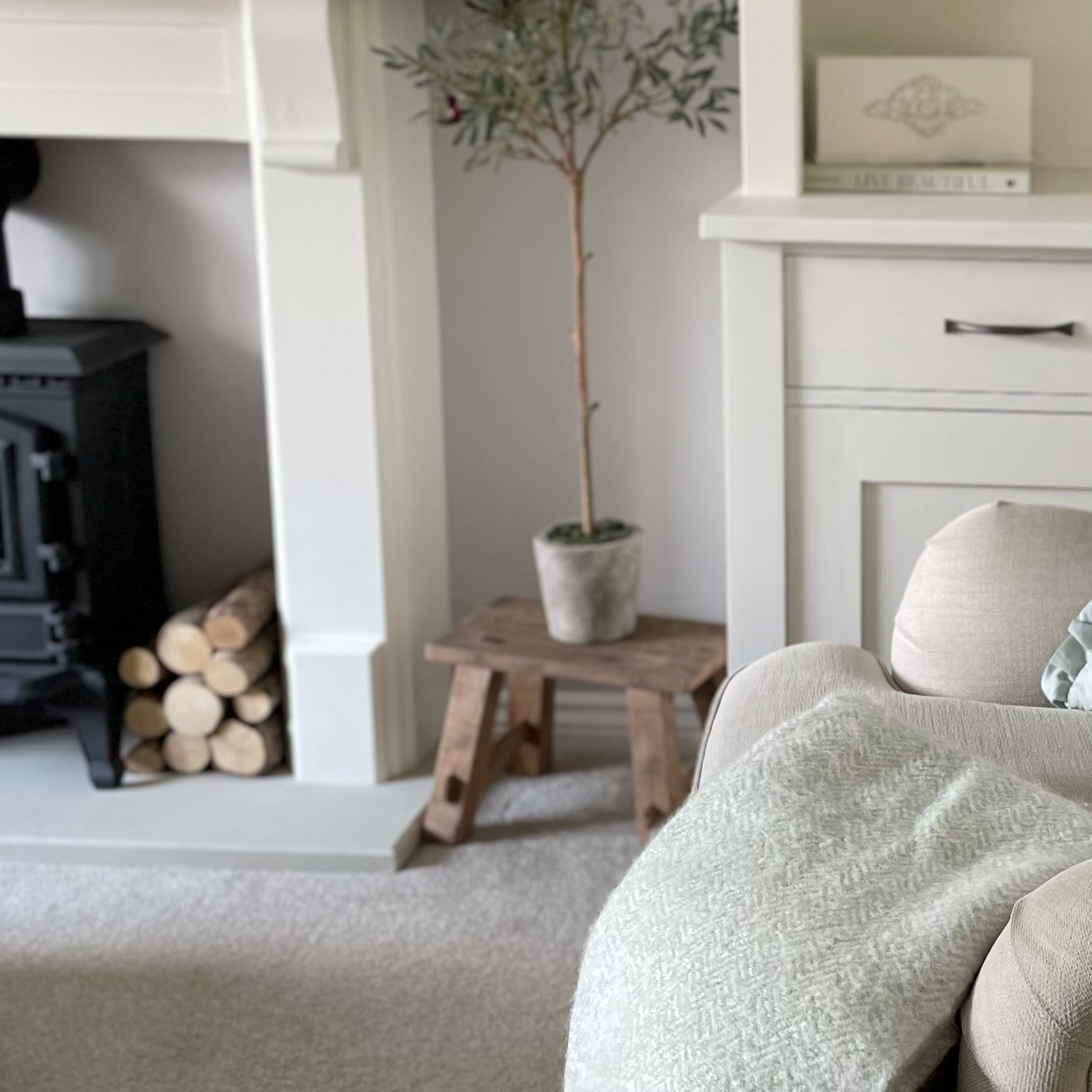 Reclaimed teak wooden display stool with rustic finish styled in a cosy home interior.