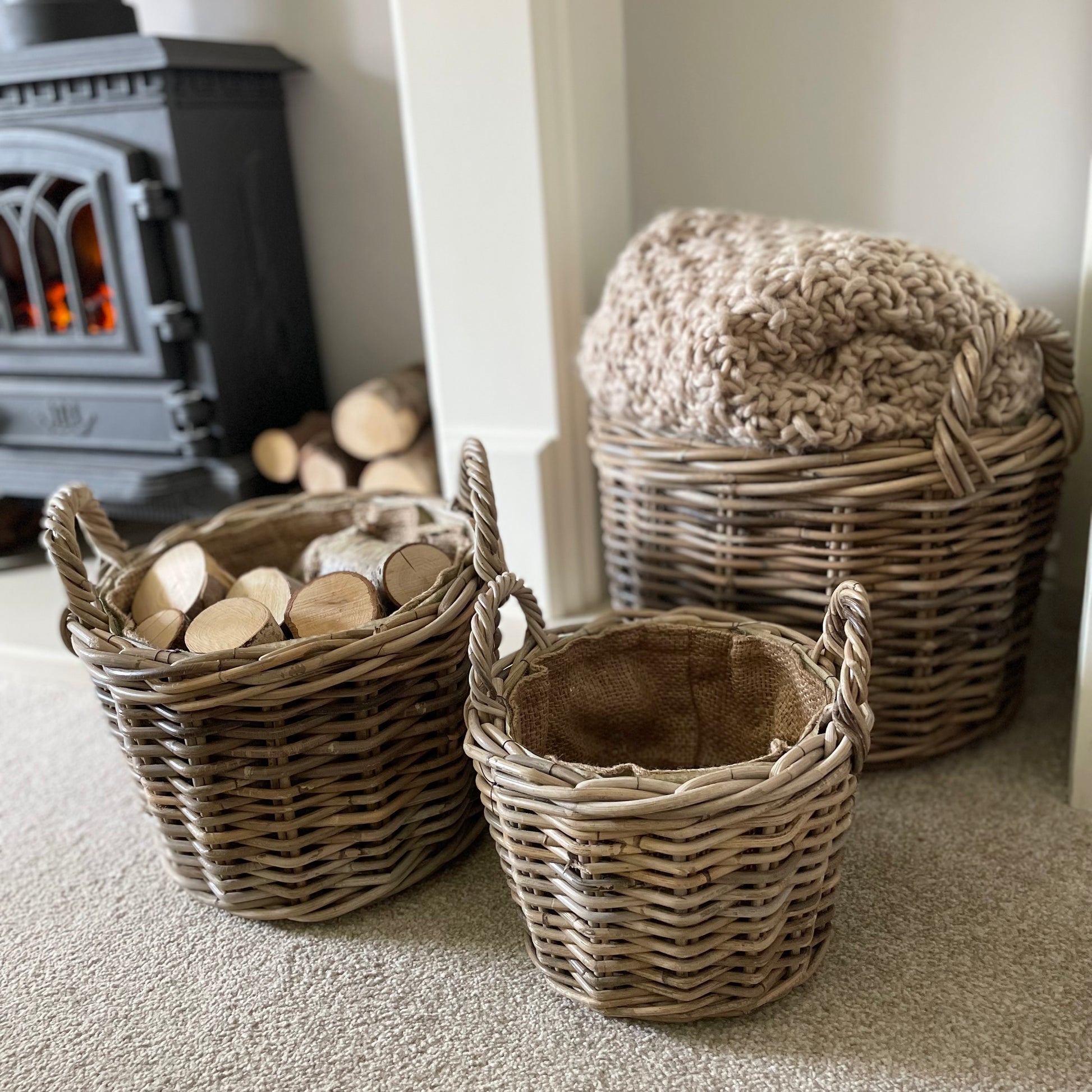 Round rattan basket with ear handles and removable hessian liner, perfect for storing throws or firewood.
