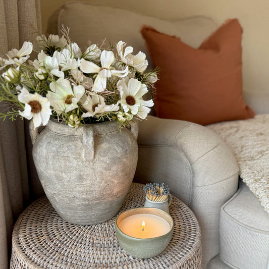 Rust cushion with textured frayed edges, adding warmth and relaxed elegance to a living space.