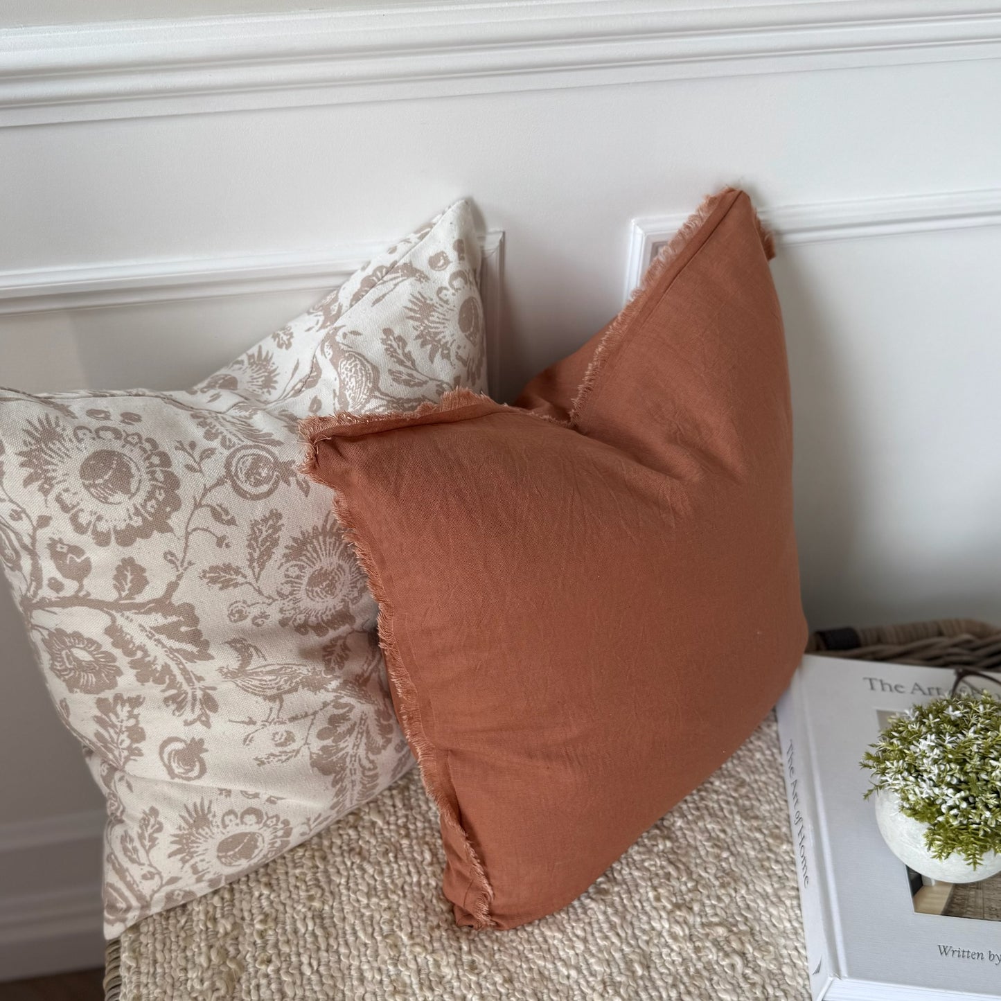 Rust cushion with textured frayed edges, adding warmth and relaxed elegance to a living space.
