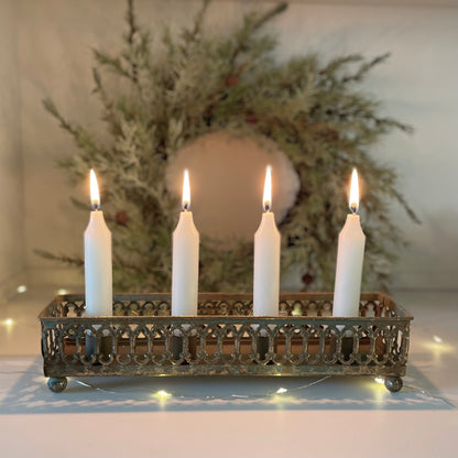 Swedish inspired tin candle holder displaying four candles. Styled on a shelf with wreath in the background.