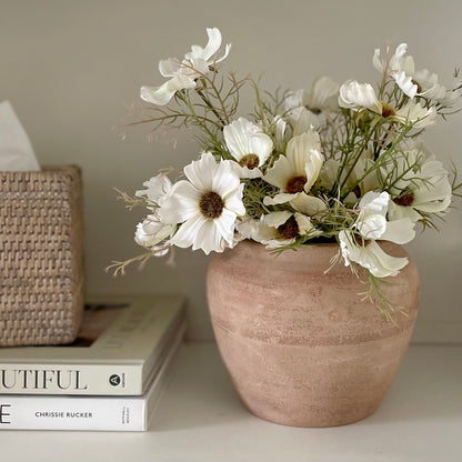 Rustic unglazed terracotta Henley pot with natural finish. Styled with cosmos spray on a shelf with books and rattan tissue box.