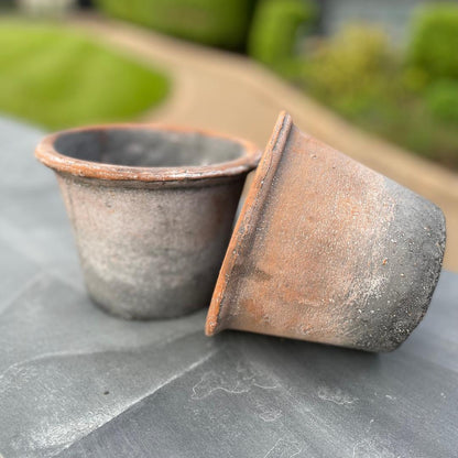 rustic stone plant pot styled in a garden